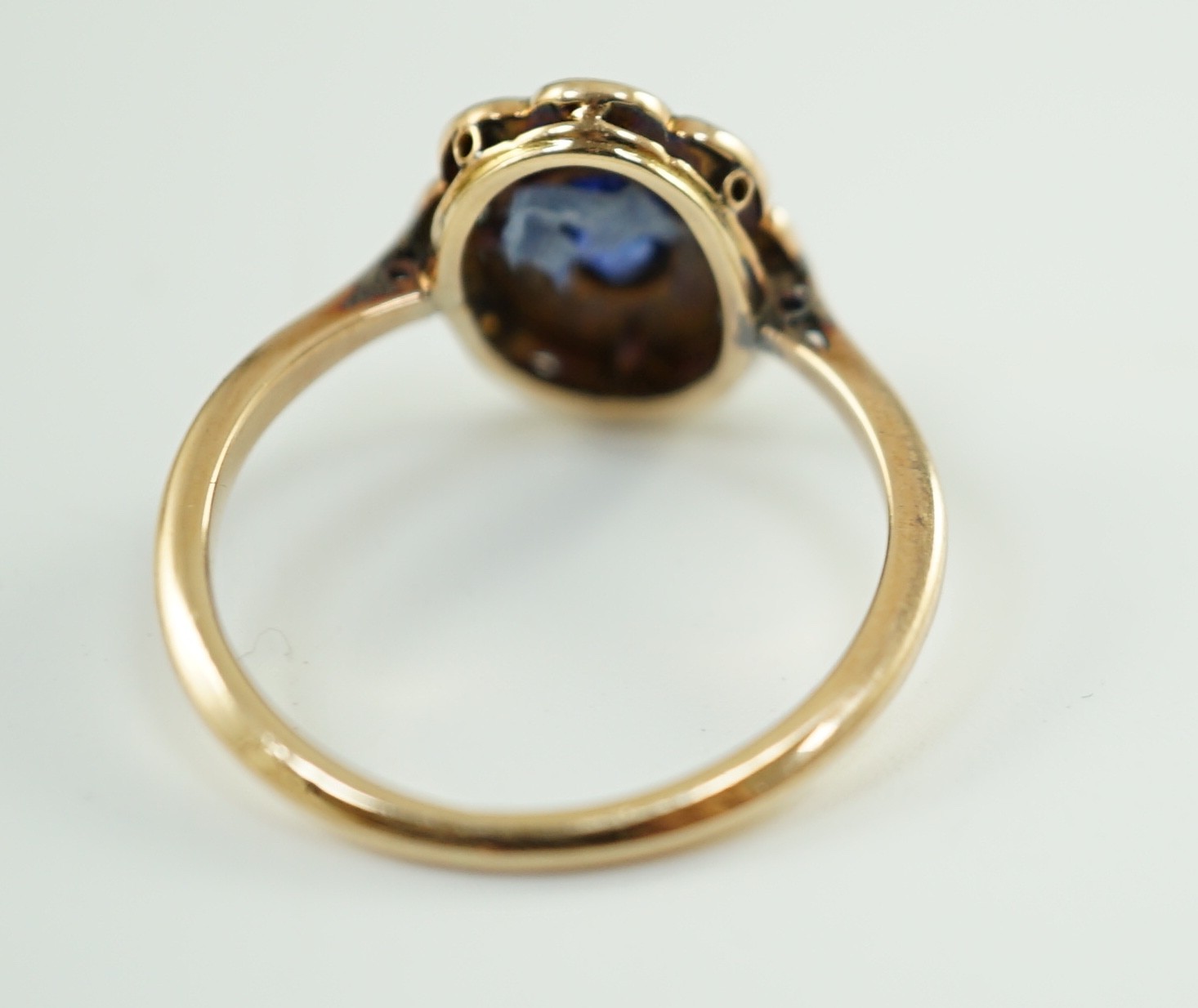 An early 20th century gold, sapphire and millegrain set rose cut diamond set oval cluster ring